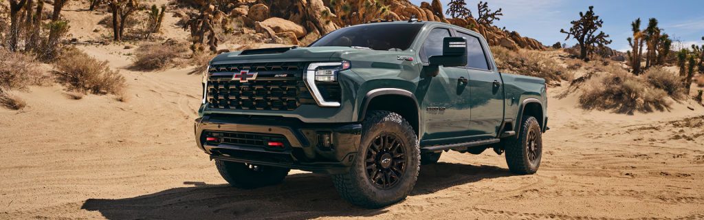 Green Chevy truck on a dirt road.