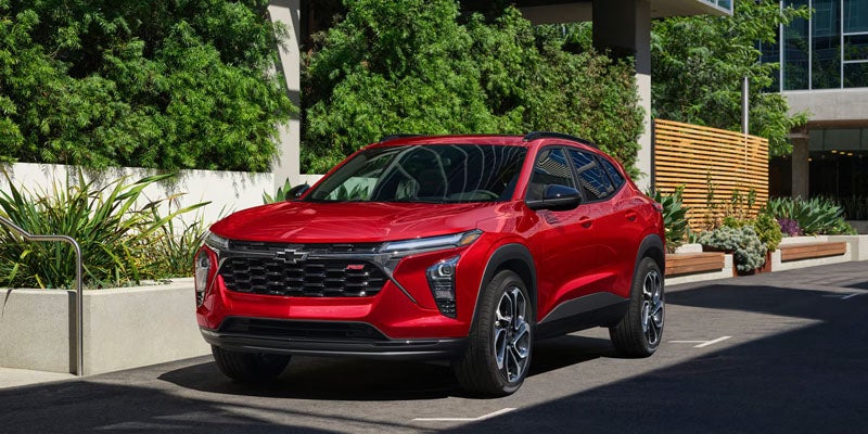 Chevrolet Trax SUV parked outside a modern building with landscaped surroundings.
